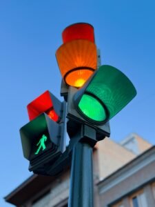 A close-up of a traffic light showing green and orange under a clear evening sky in Murcia, Spain.